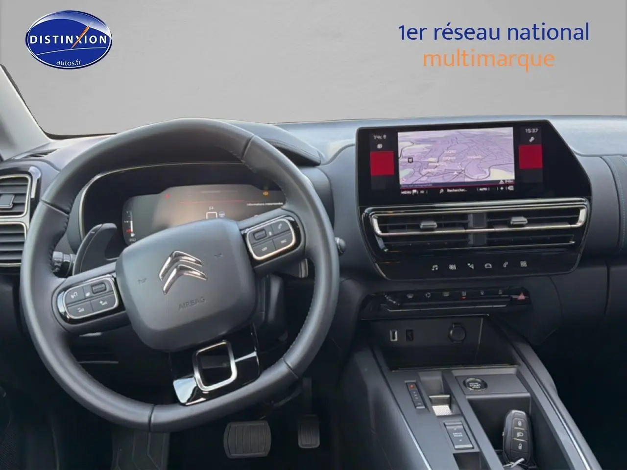 Vue intérieure centrée sur le volant cuir et l’écran tactile du tableau de bord du Citroën C5 Aircross gris platinium.