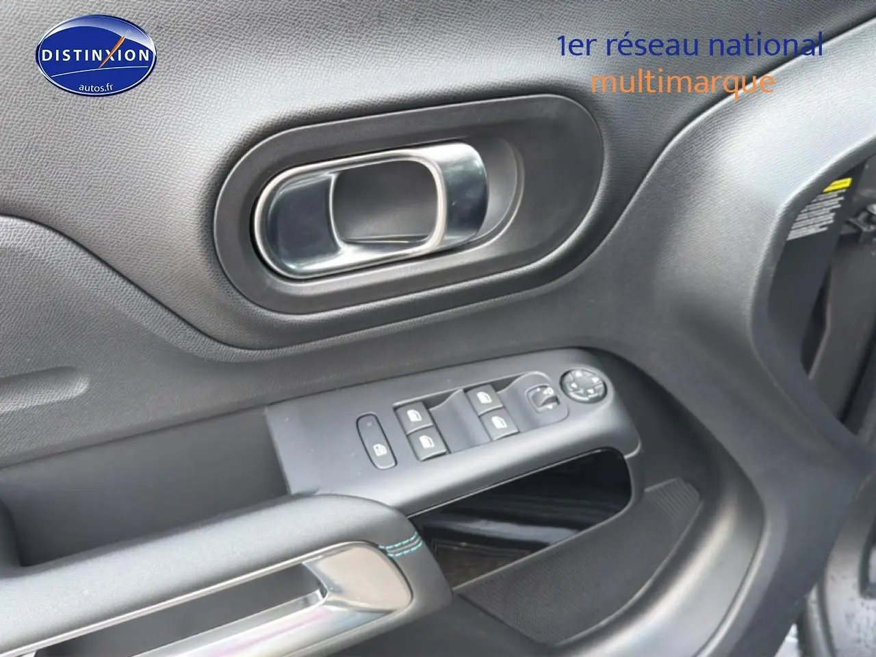 Gros plan sur la porte avant gauche du Citroën C5 Aircross gris platinium, avec commandes de vitres et poignée chromée.