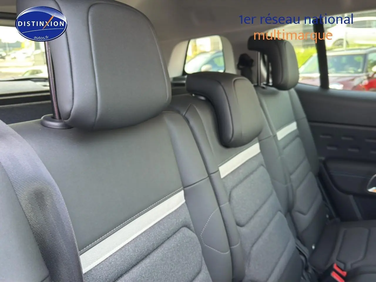 Vue latérale intérieure sur la deuxième rangée de sièges noirs et gris du Citroën C5 Aircross 2025 hybride.
