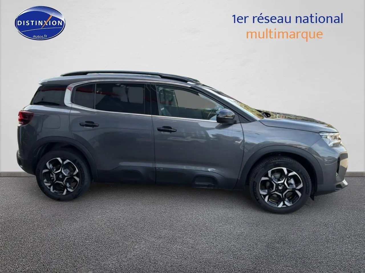 Profil droit du Citroën C5 Aircross gris platinium 2025 avec barres de toit et jantes alu distinctives.