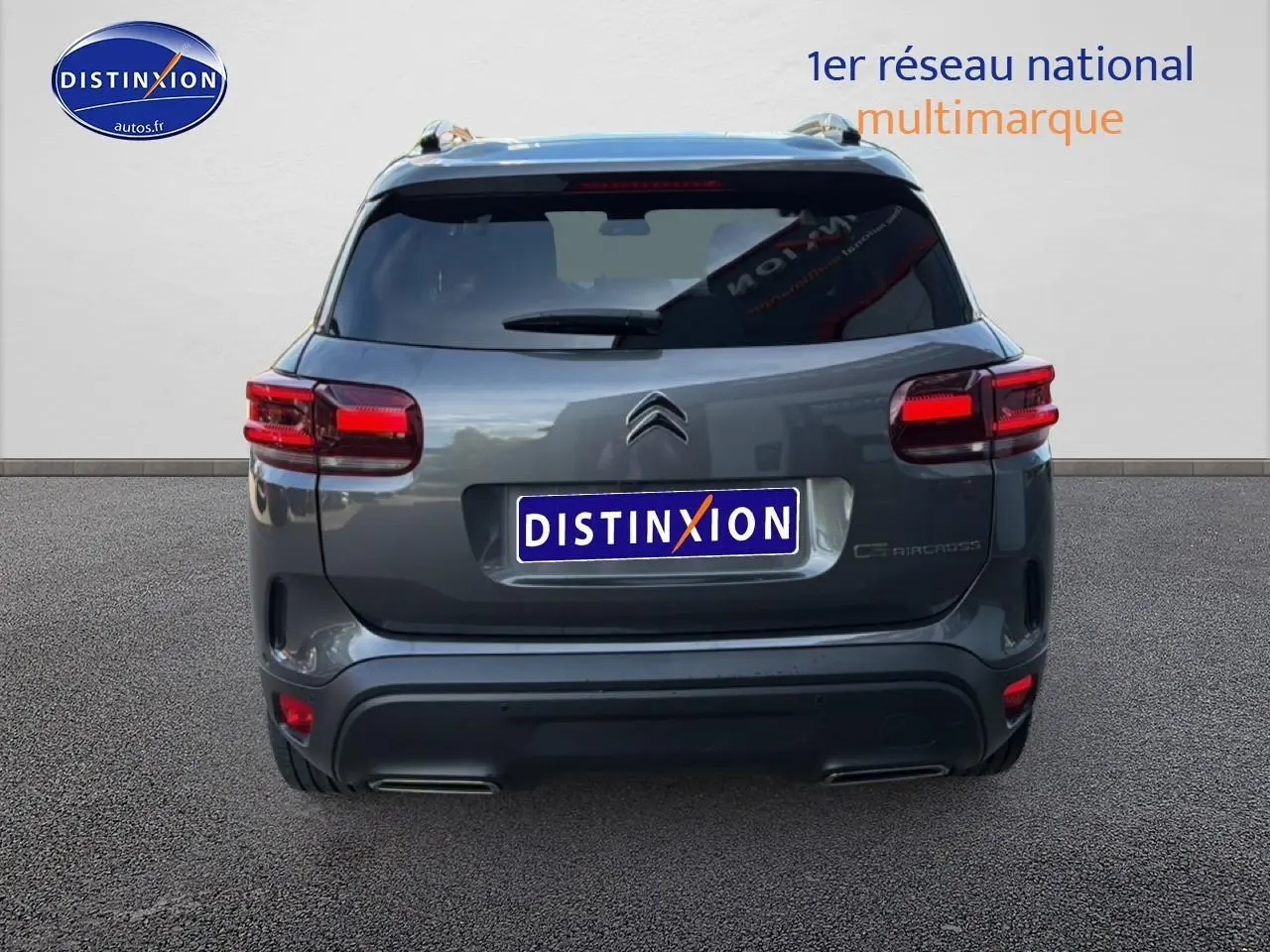 Vue arrière d'un Citroën C5 Aircross gris platinium avec feux LED et barres de toit visibles.