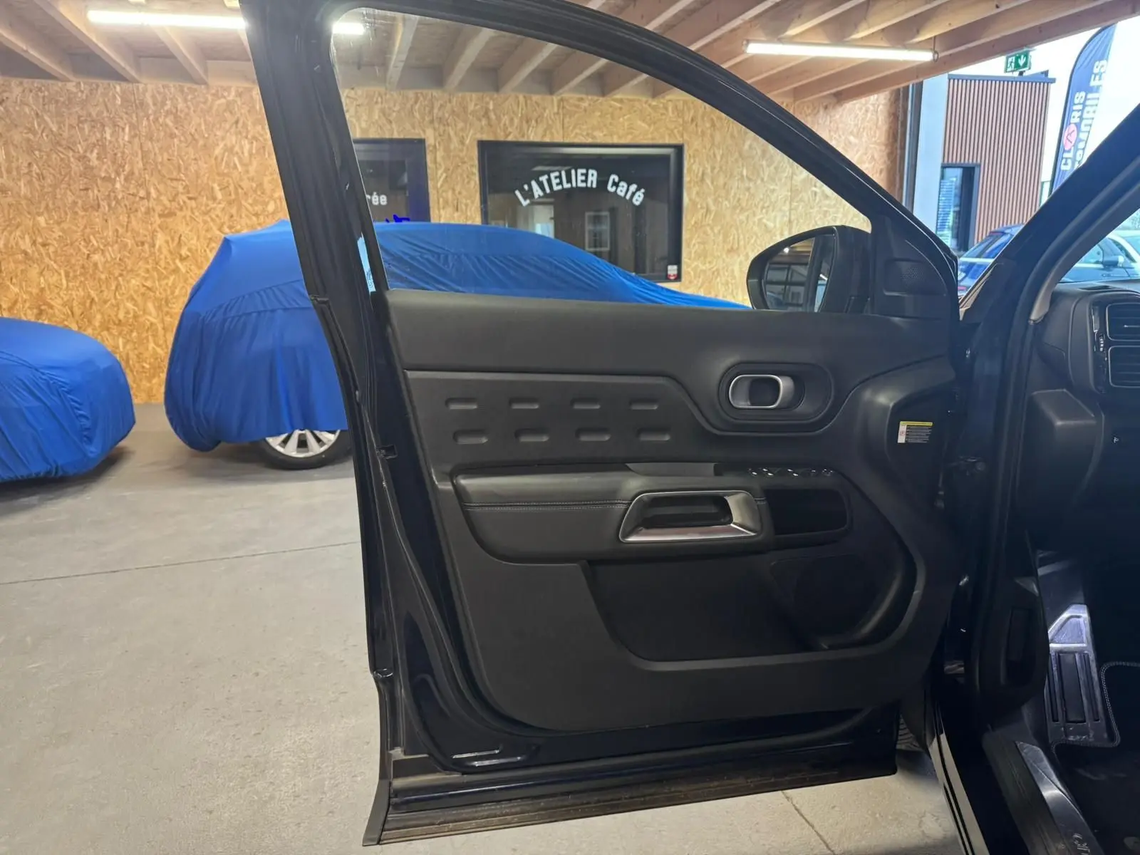 Gros plan sur la jante alu 18 pouces noire et argentée du Citroën C5 Aircross bleu, avec logo Citroën au centre.