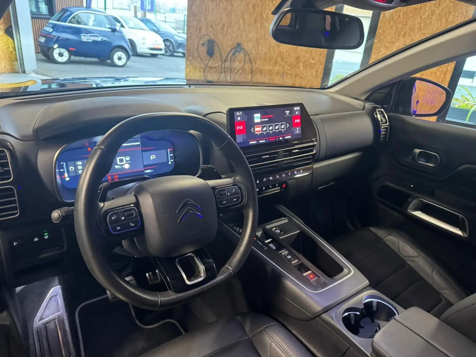 Gros plan sur la porte avant gauche noire du Citroën C5 Aircross avec commandes de vitres et poignée argentée.