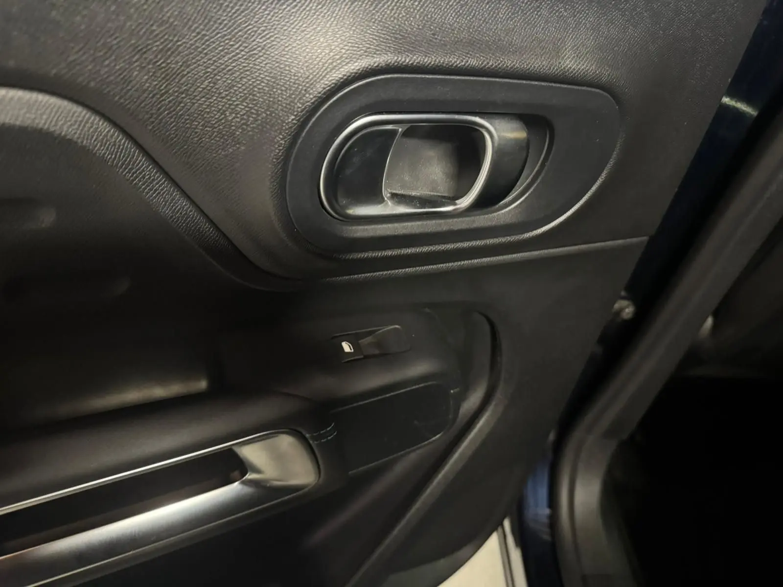 Coffre ouvert vu de l'arrière d'un Citroën C5 Aircross bleu, espace de chargement vide avec éclairage intérieur.