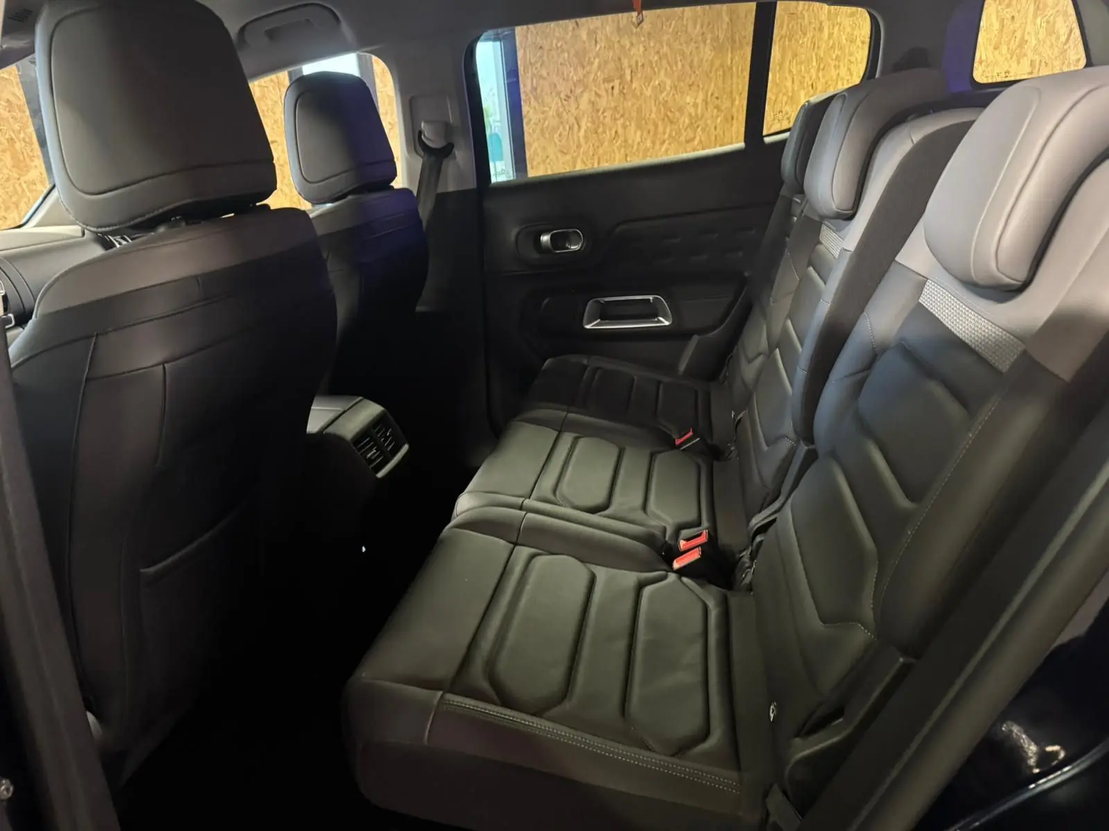 Vue intérieure côté droit des sièges arrière en cuir noir du Citroën C5 Aircross bleu, avec appuie-têtes et ceintures visibles.