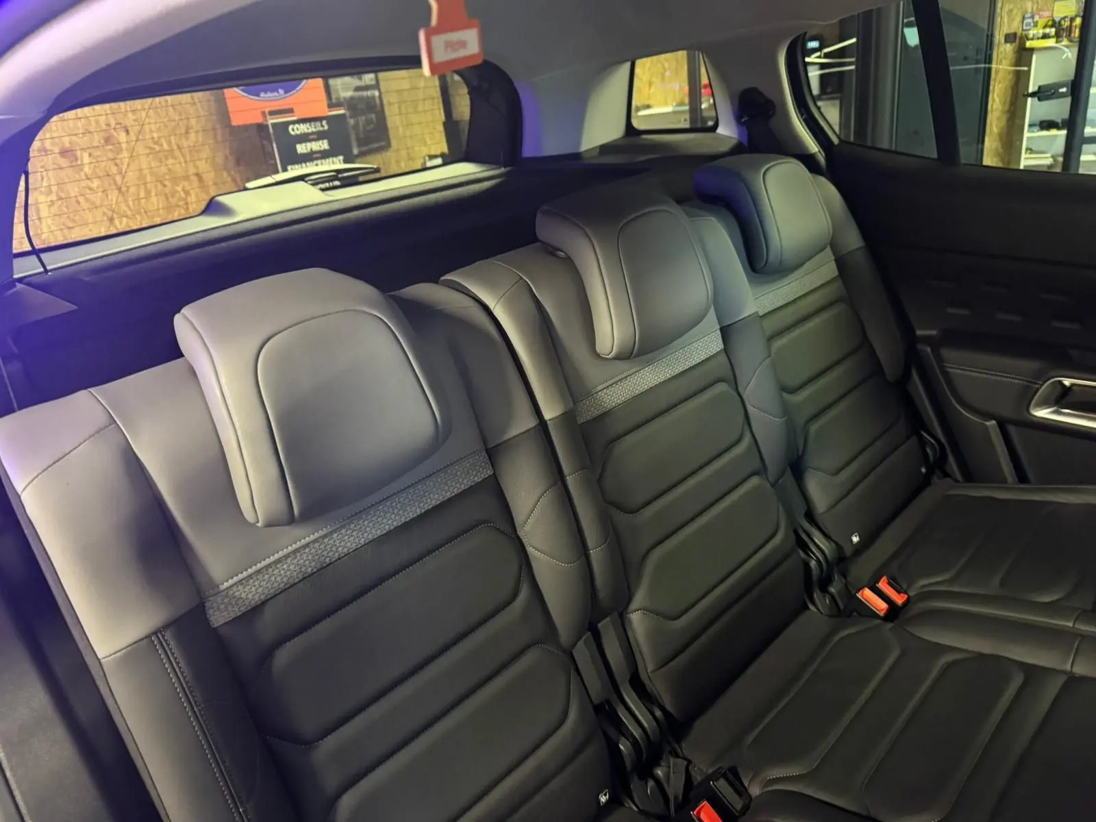 Vue intérieure côté gauche des sièges arrière noirs du Citroën C5 Aircross bleu avec portes ouvertes.