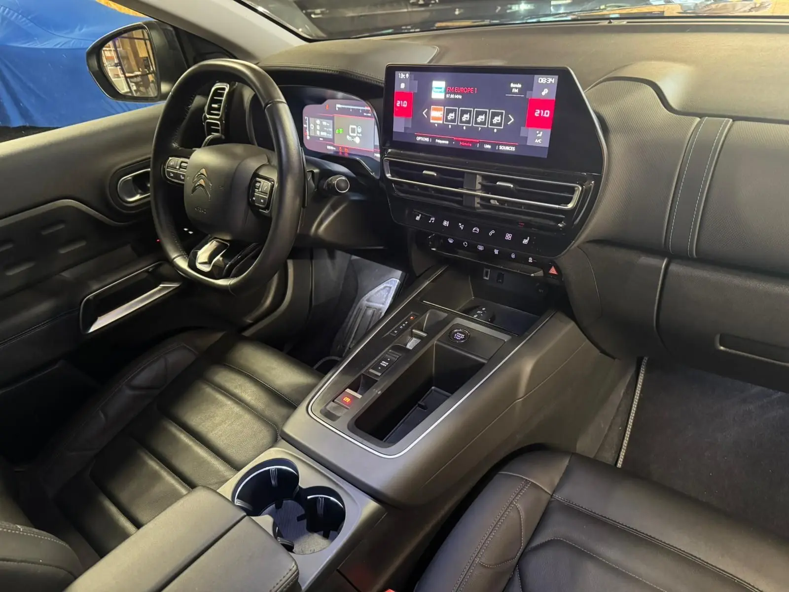 Vue intérieure côté conducteur du Citroën C5 Aircross 2022, sièges cuir noirs avec surpiqûres grises et console centrale visible.