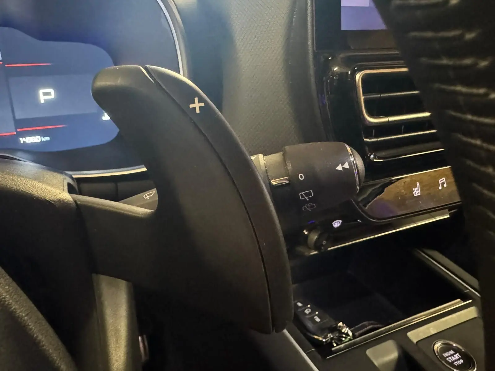 Gros plan sur la palette de changement de vitesses droite noire dans l’habitacle du Citroën C5 Aircross bleu, avec tableau de bord numérique en arrière-plan.