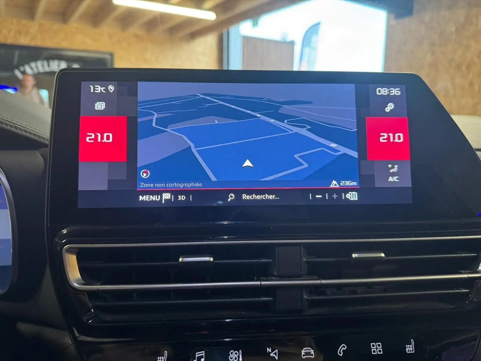 Vue plongeante sur la console centrale noire du Citroën C5 Aircross avec clé, frein à main électrique et porte-gobelets.