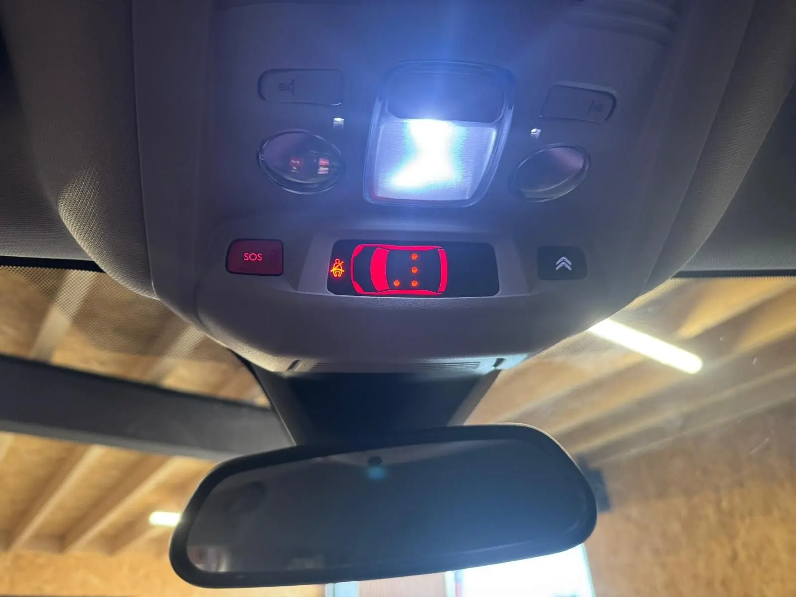 Gros plan sur les commandes de réglage des phares et d’aide à la conduite côté gauche d’un Citroën C5 Aircross bleu.