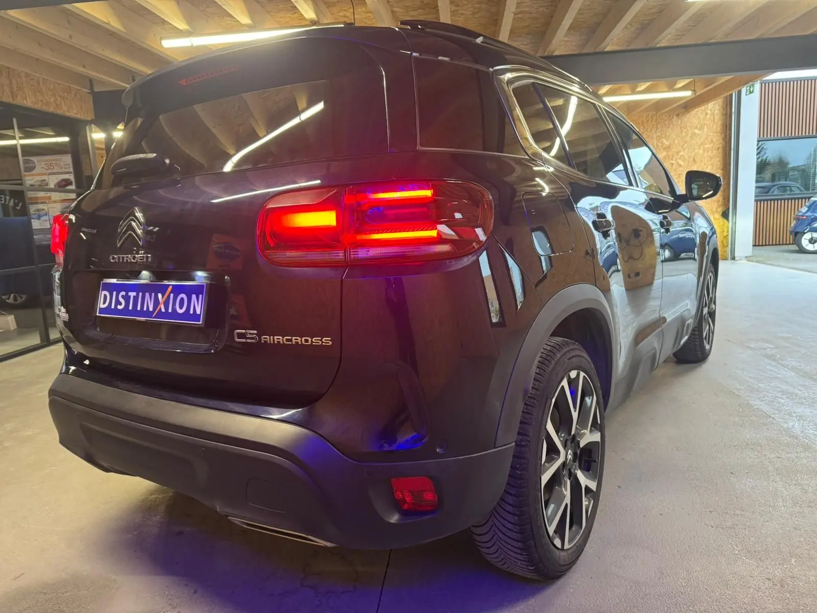 Vue arrière d'un Citroën C5 Aircross bleu 2022 avec feux LED allumés dans un garage.