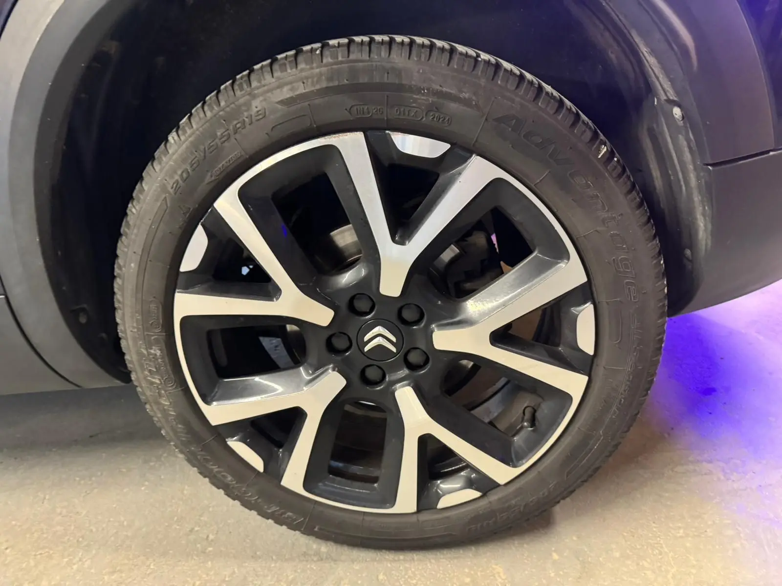 Vue 3/4 arrière droite d'un Citroën C5 Aircross bleu avec feux arrière LED allumés et jantes alu 18 pouces.