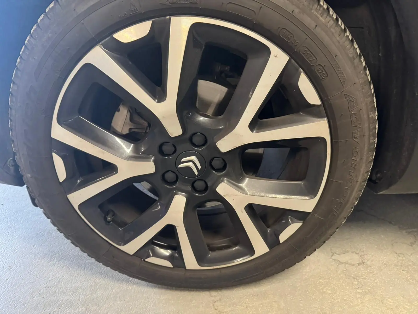 Gros plan sur une jante alu 18 pouces bicolore avec logo Citroën au centre, montée sur un pneu noir.