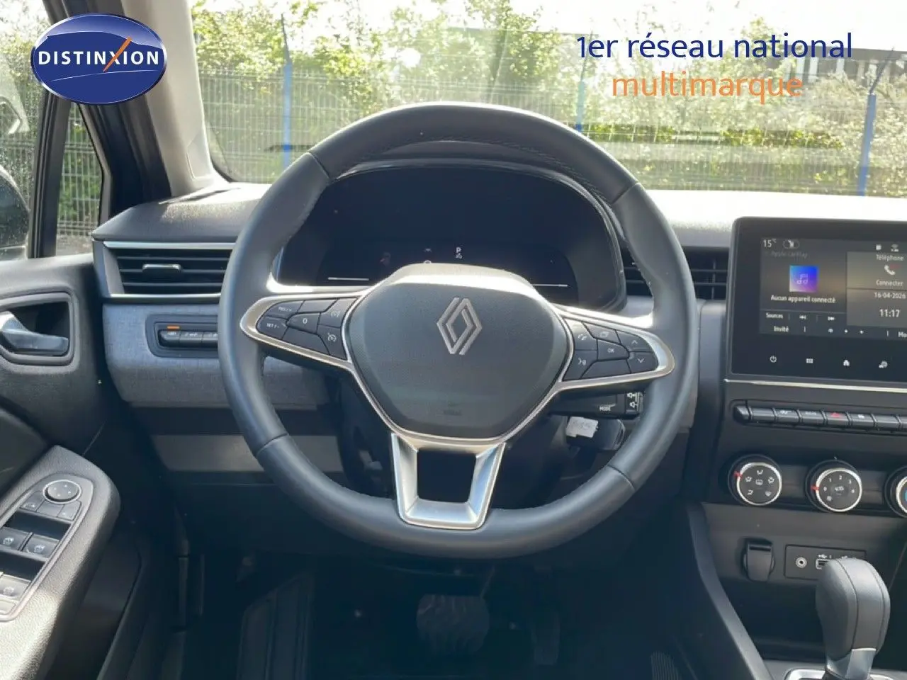 Vue intérieure centrée sur le volant cuir multifonction et l’écran tactile de la Renault Clio 2025, ambiance noire moderne.