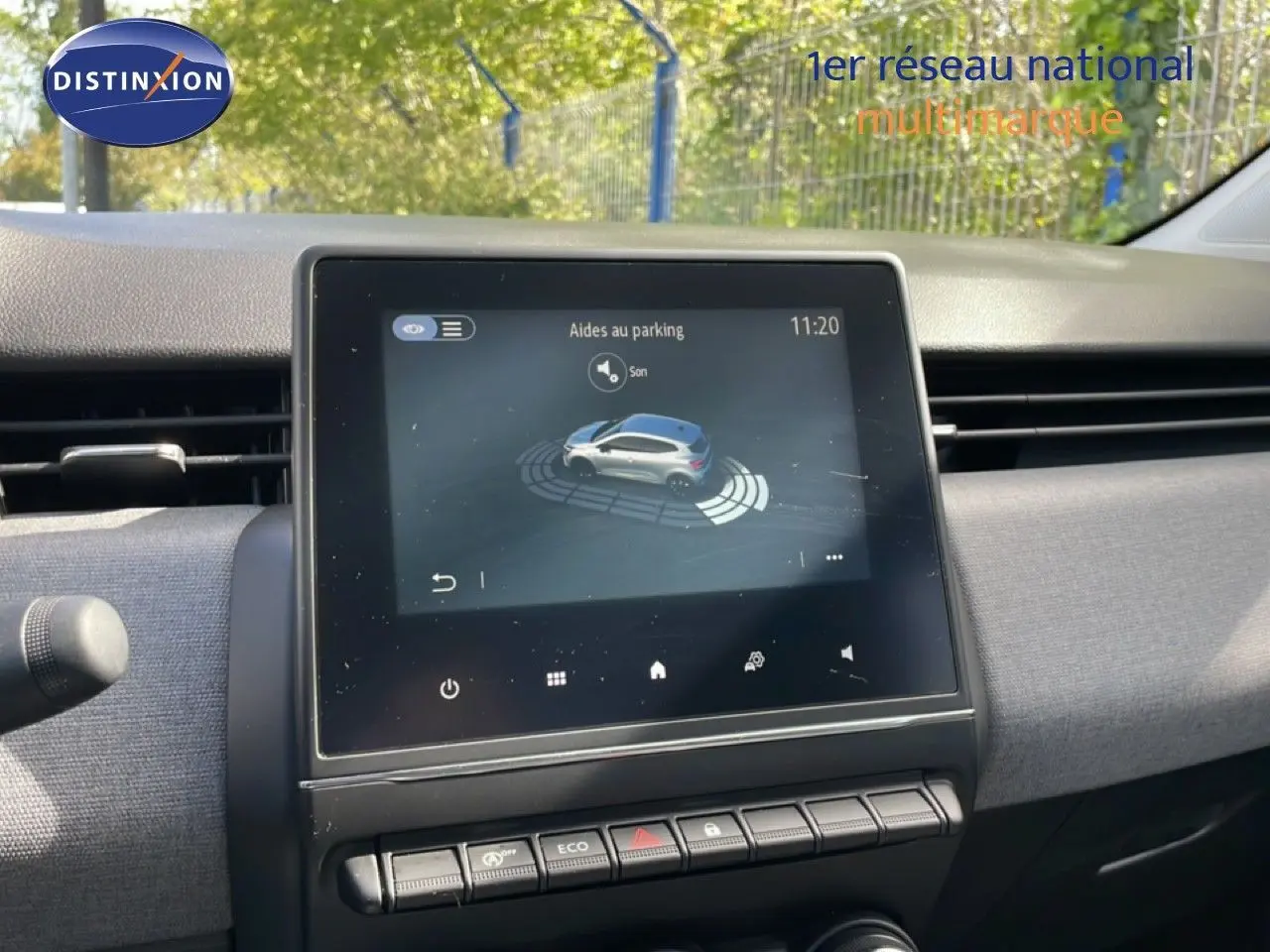 Écran central tactile de la Renault Clio gris schiste, affichant l'aide au parking, vue intérieure avant.