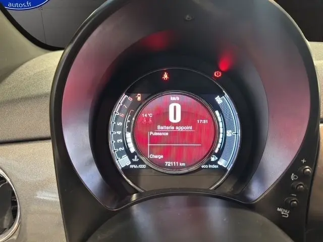 Gros plan sur le tableau de bord numérique circulaire de la Fiat 500 gris foncé, affichant 0 km/h et 72 111 km au compteur.