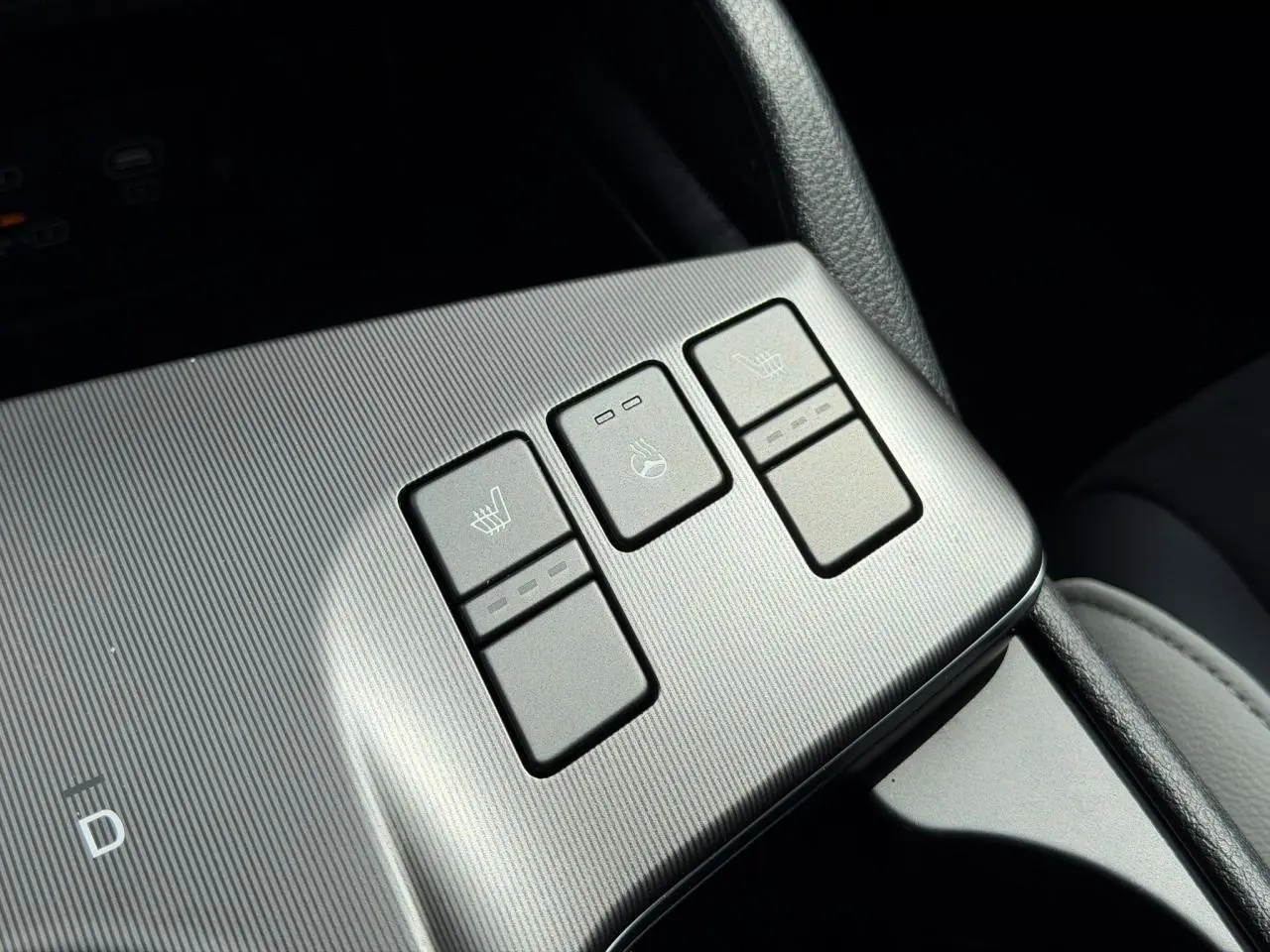Gros plan sur les boutons de chauffage et ventilation des sièges du KIA SPORTAGE blanc, version GT-line 2026.