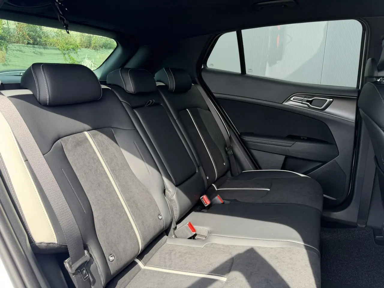 Vue latérale droite de la banquette arrière bi-ton noir et gris du Kia Sportage 2026 GT-line.