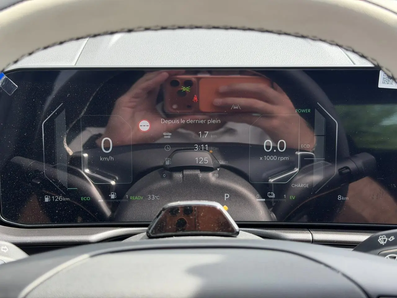 Tableau de bord digital 12,3'' du Kia Sportage blanc, affichage vitesse, autonomie et mode hybride.