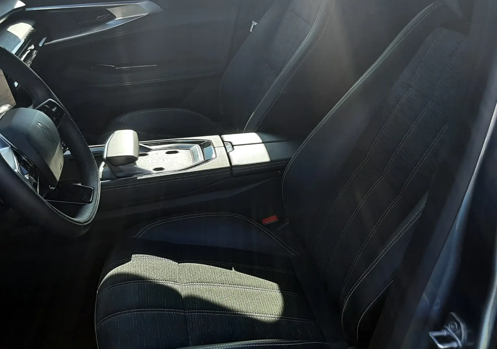 Intérieur noir du Renault Austral 2025, vue côté conducteur, avec sièges en tissu et console centrale moderne.