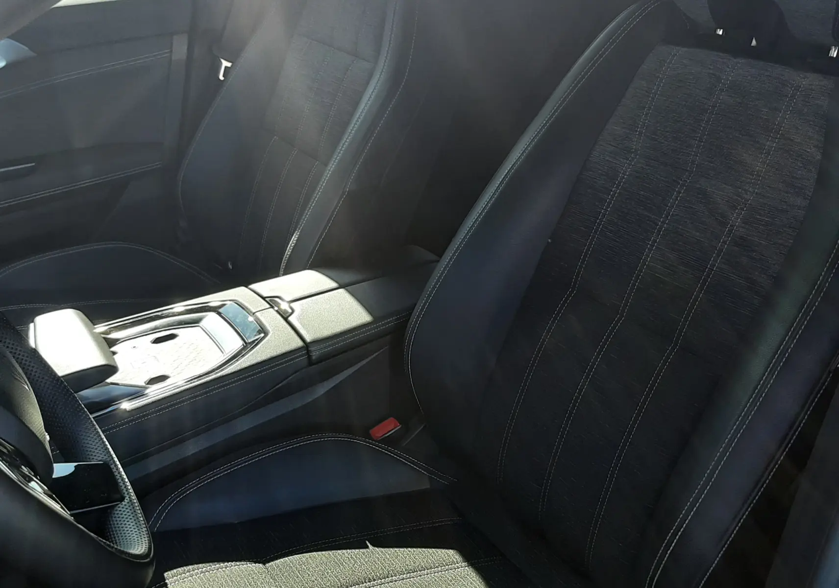 Vue intérieure rapprochée des sièges avant noirs en tissu et cuir du Renault Austral E-Tech Full Hybrid 2025.
