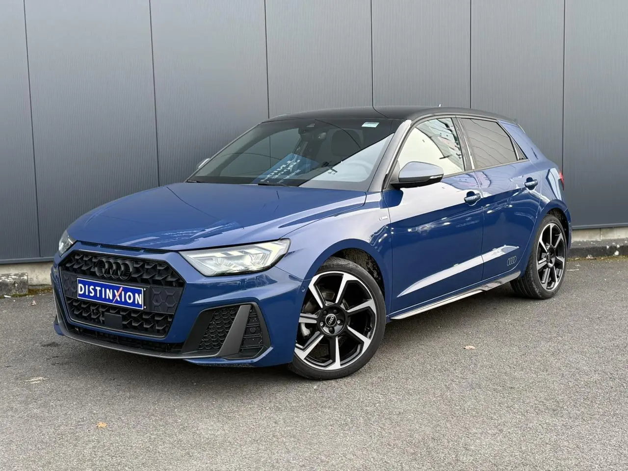 Audi A1 Sportback 30 TFSI bleu Ascari en 3/4 avant droit avec toit et arches noirs, jantes Rotor anthracite 18 pouces