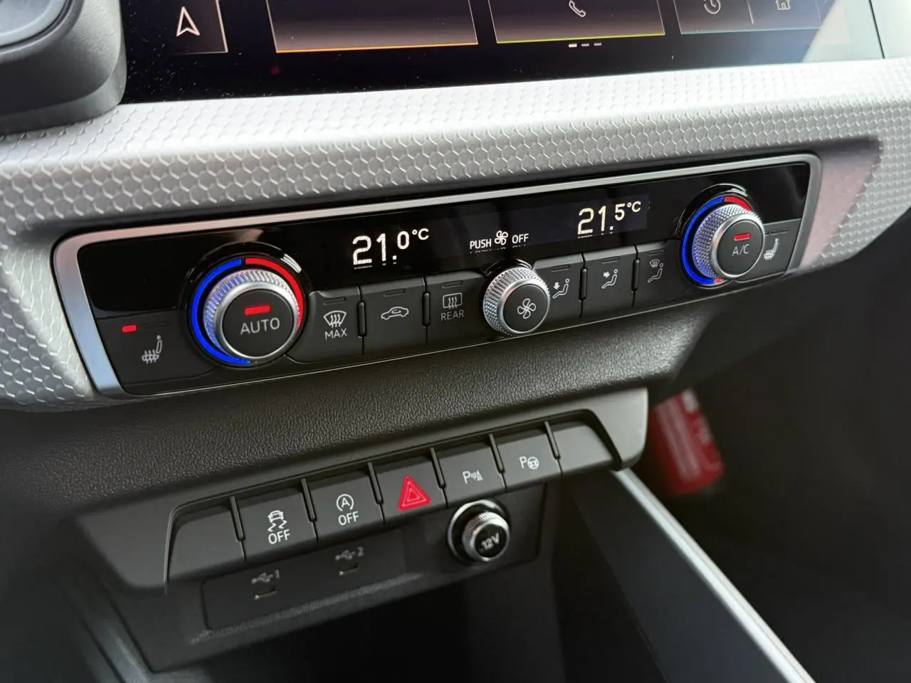 Détail du tableau de bord de l'Audi A1 Sportback 30 TFSI 2023 montrant la console de climatisation et les commandes en noir et argent.