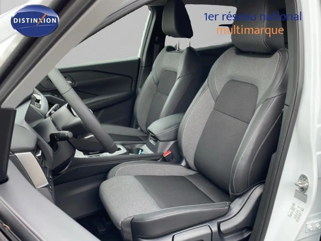 Vue intérieure côté conducteur du Nissan Qashqai blanc 2025, mettant en valeur les sièges bicolores et le volant cuir.