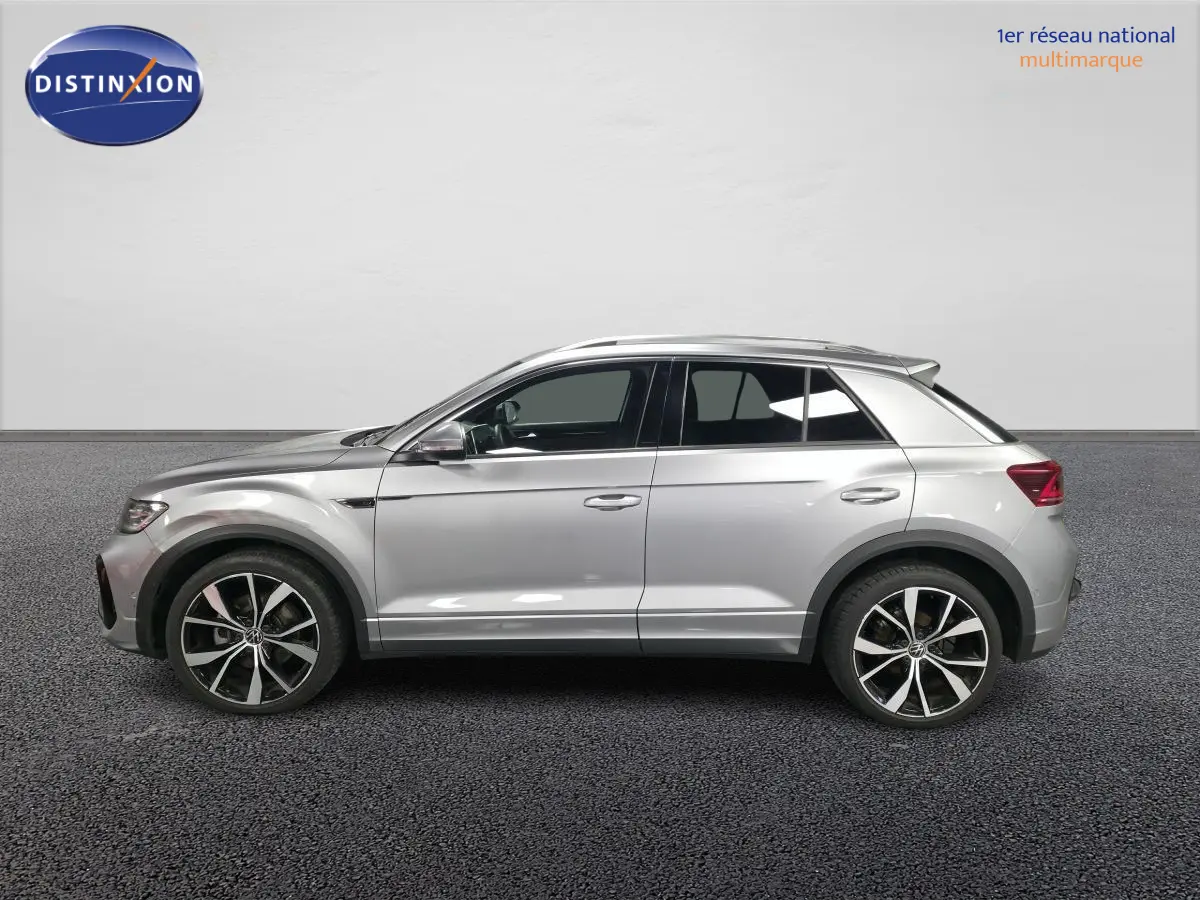 Vue de profil côté gauche d'un Volkswagen T-Roc gris métallisé avec jantes alliage 19 pouces et finitions R-Line.
