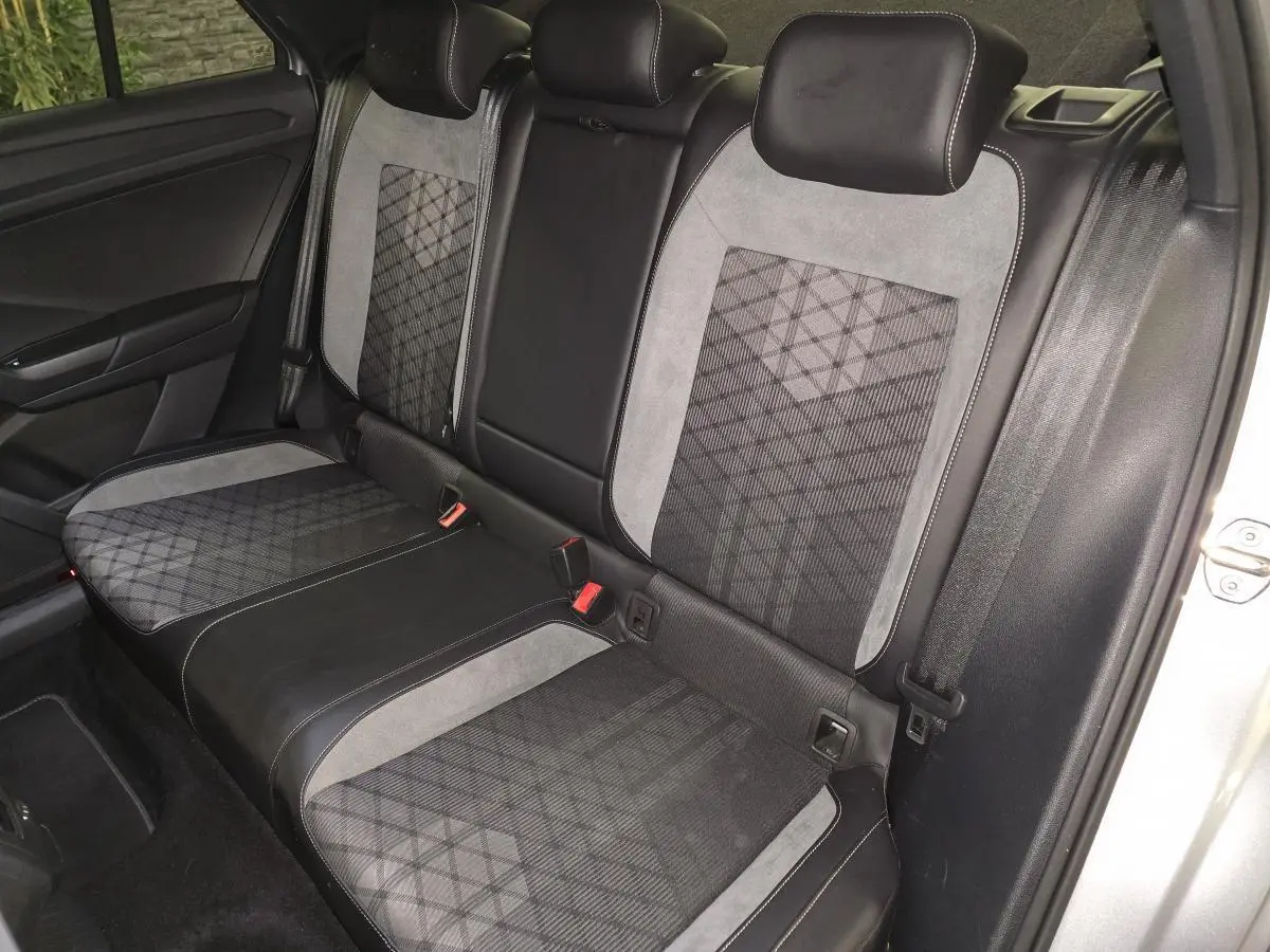 Vue intérieure sur la banquette arrière du Volkswagen T-Roc 2025 avec sellerie tissu et similicuir gris à motifs géométriques.