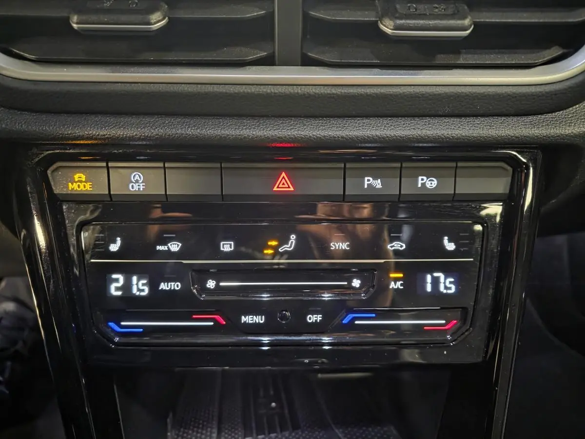 Détail du tableau de bord noir du Volkswagen T-Roc 2025, montrant la climatisation automatique bi-zone et commandes tactiles.