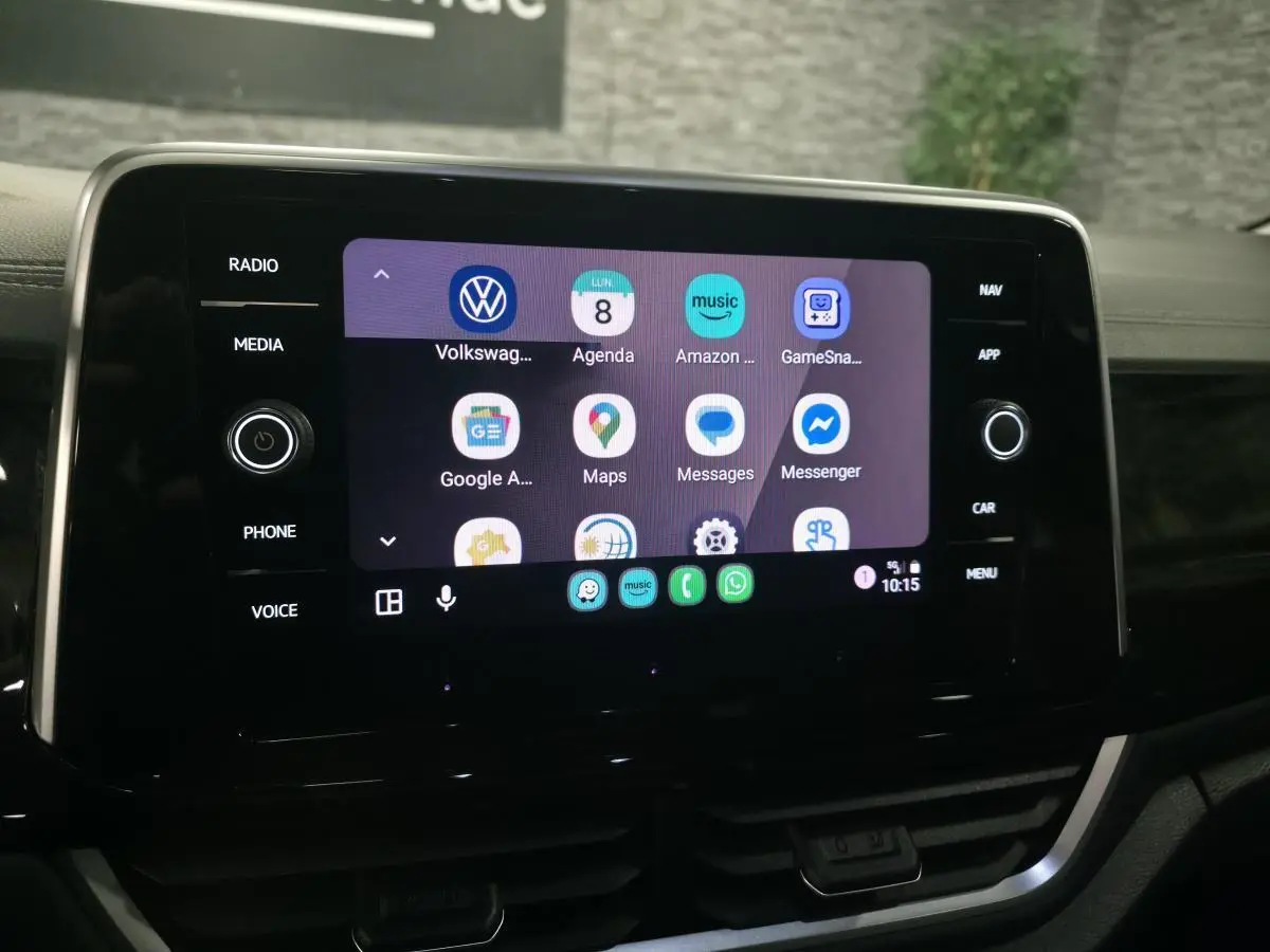 Écran tactile central du Volkswagen T-Roc 2025 affichant des applications connectées, intérieur noir.