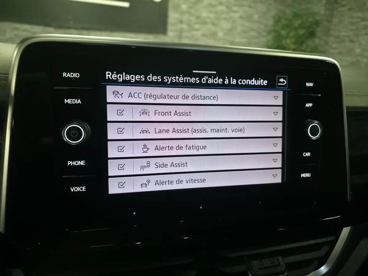 Écran tactile intérieur du Volkswagen T-Roc 2025 affichant les réglages des aides à la conduite.