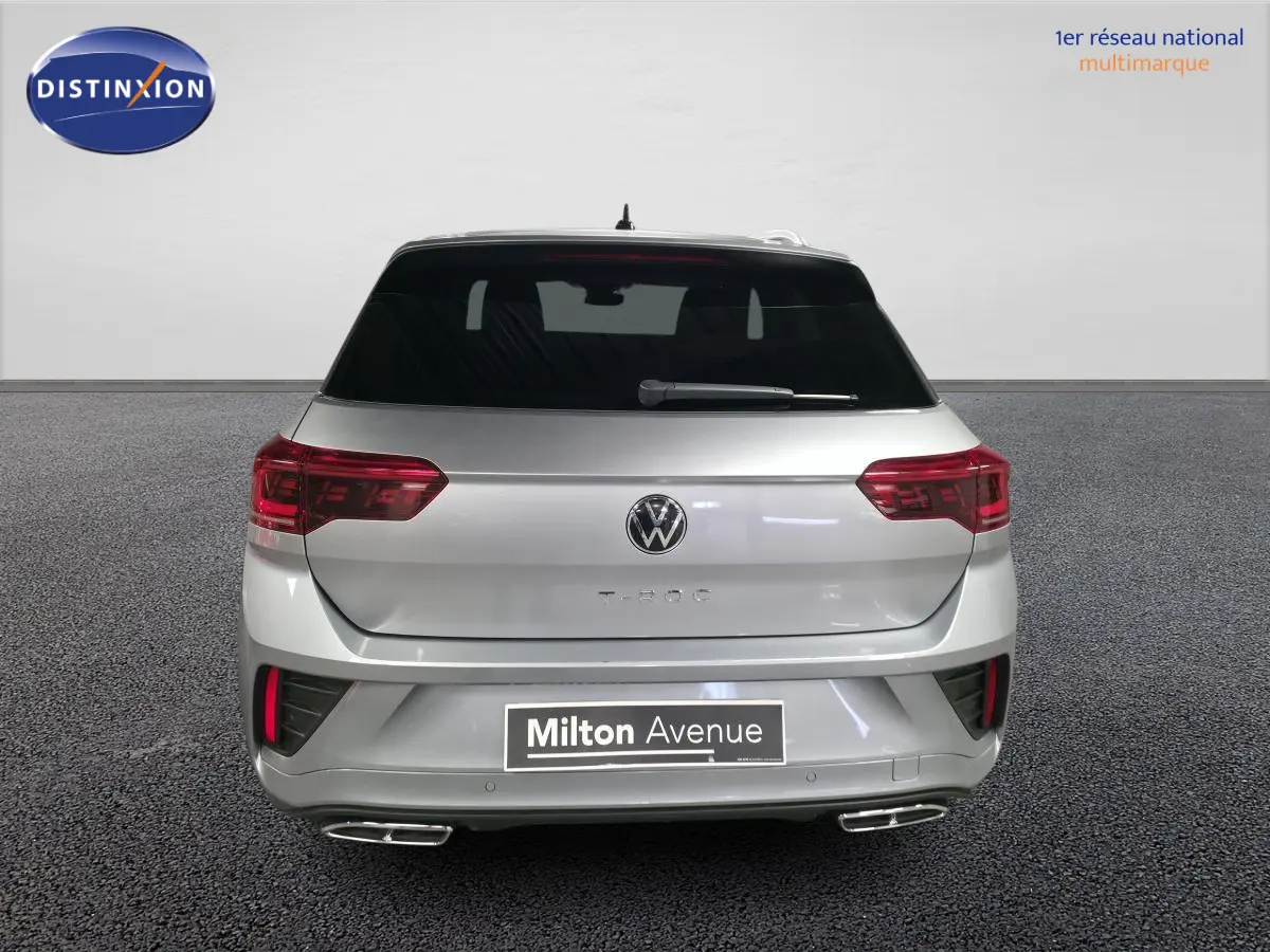 Vue arrière d'un Volkswagen T-Roc gris métallisé 2025 avec feux LED et double sortie d'échappement chromée.