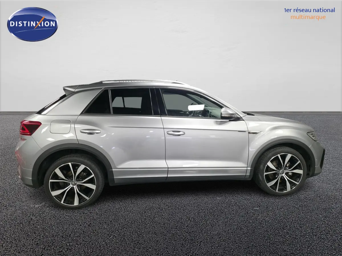 Vue de profil côté gauche d'un Volkswagen T-Roc gris métallisé avec jantes alliage 19 pouces et détails R-Line.