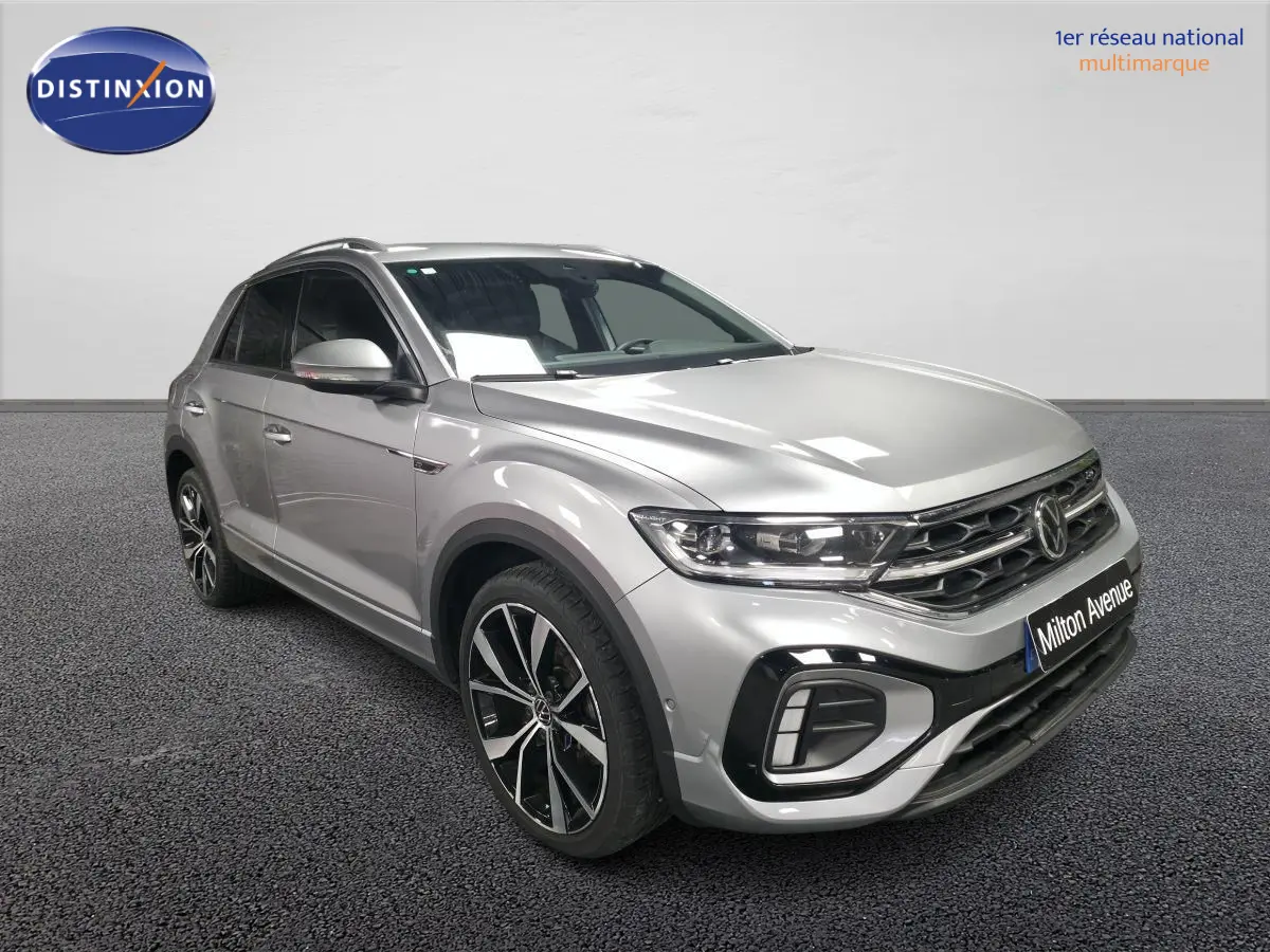 Vue 3/4 avant droit du Volkswagen T-Roc gris métallisé R-Line avec jantes alliage 19 pouces et calandre spécifique.