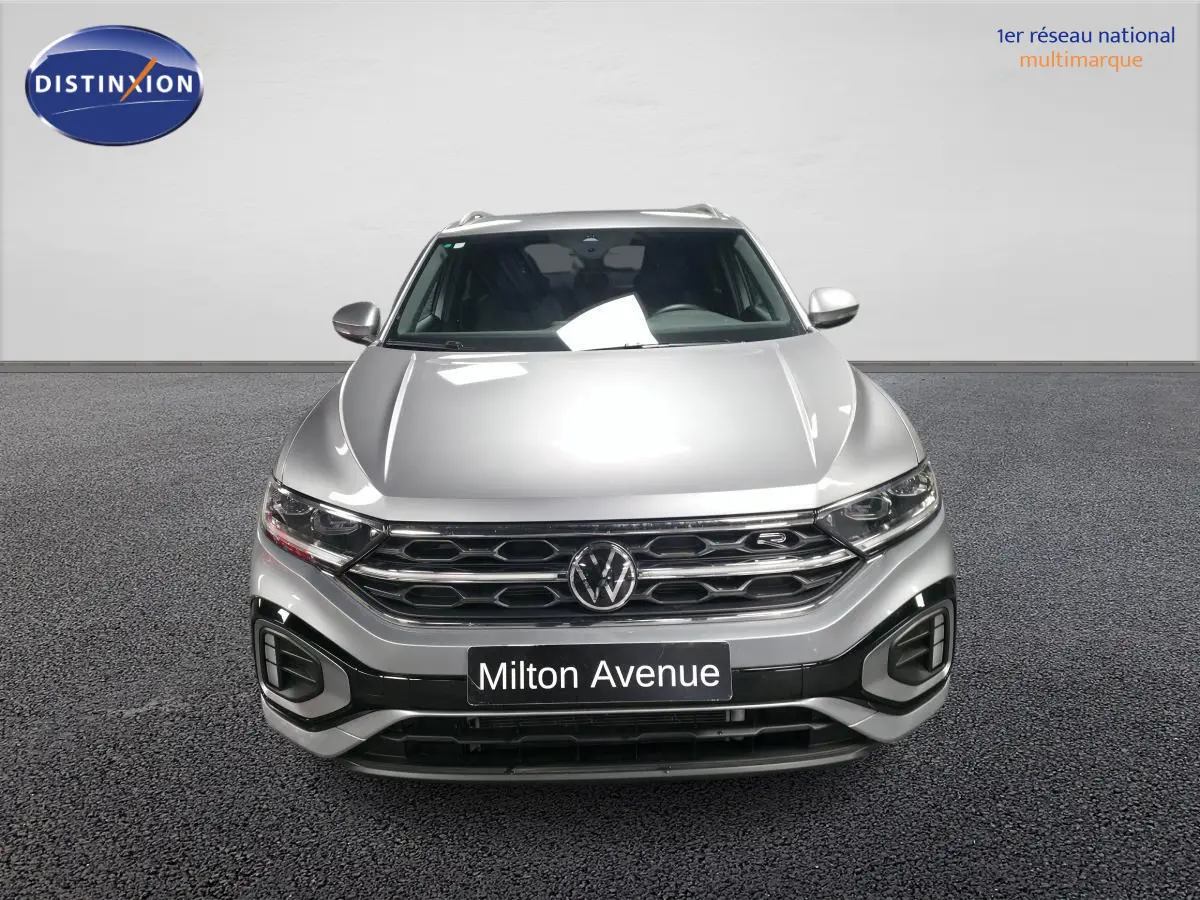 Vue frontale d'un Volkswagen T-Roc gris métallisé avec calandre R-Line et plaque Milton Avenue.