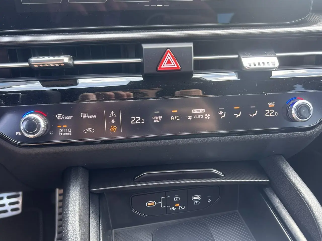 Gros plan sur la console centrale noire du Kia Sportage 2026, affichant la climatisation automatique et les commandes tactiles.
