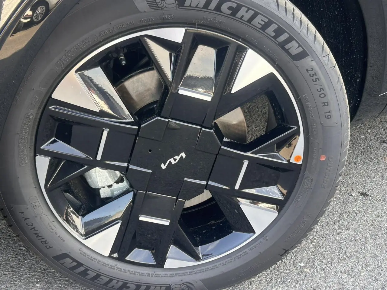 Gros plan sur la jante alliage 19 pouces noire et argentée du Kia Sportage 2026 avec logo Kia central.