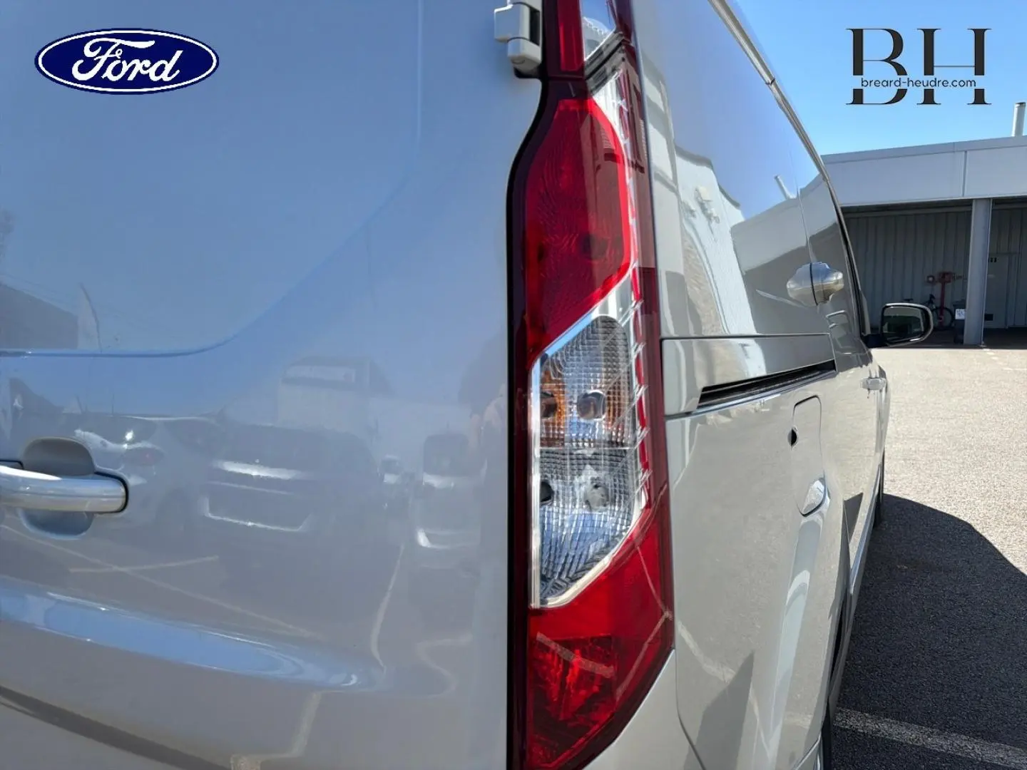 Vue arrière côté droit du Ford Transit Connect gris lunaire métallisé, mettant en valeur le feu arrière vertical et la porte latérale.