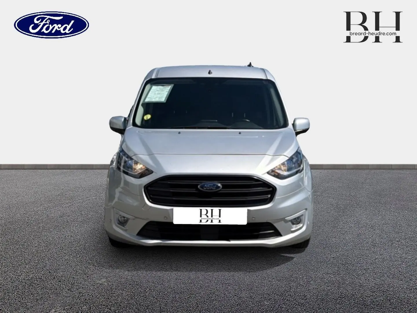 Vue frontale du Ford Transit Connect FGN L2 gris lunaire métallisé, mettant en valeur sa calandre noire et ses phares halogènes.