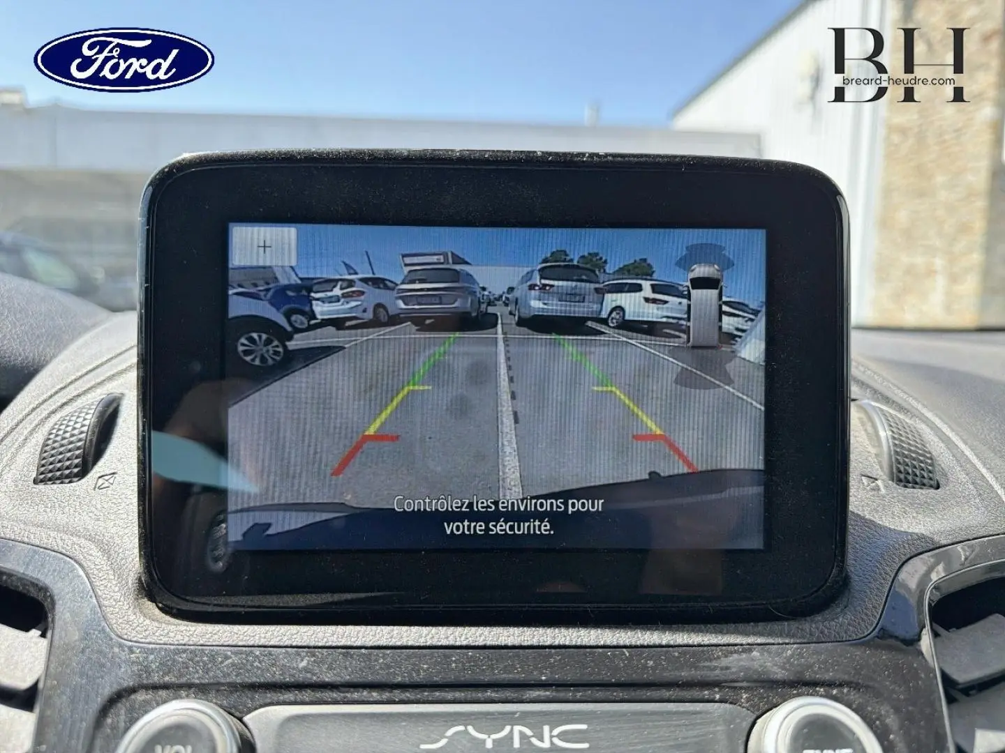 Écran tactile central montrant la caméra de recul du Ford Transit Connect gris lunaire, vue intérieure avant du tableau de bord.