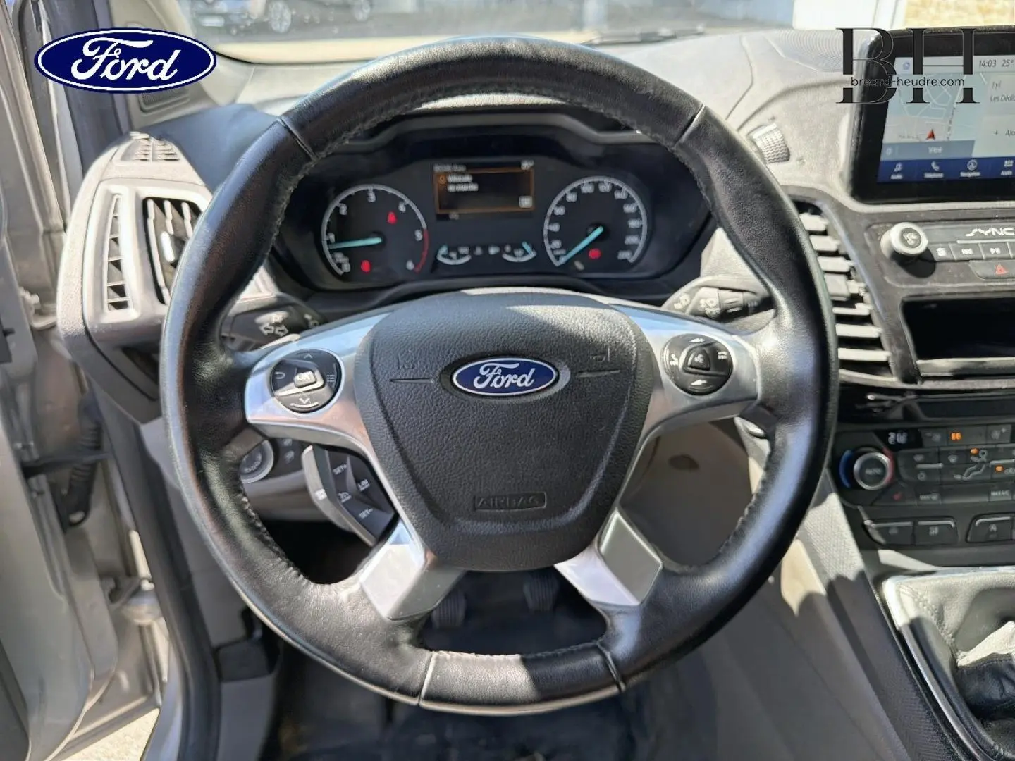 Vue intérieure centrée sur le volant en cuir noir du Ford Transit Connect 2022 avec tableau de bord et écran tactile visibles.