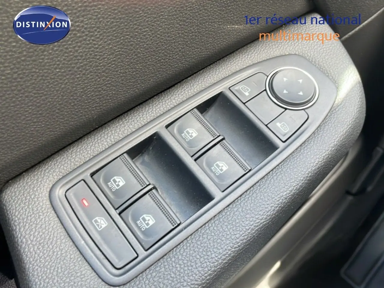 Gros plan sur les commandes des vitres et rétroviseurs côté conducteur d'une Renault Clio 2025 gris schiste métal.