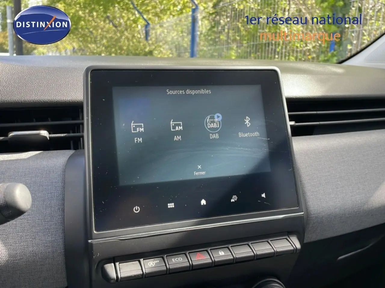 Vue intérieure centrée sur l'écran tactile multimédia de la Renault Clio gris schiste métal, affichant les sources audio disponibles.