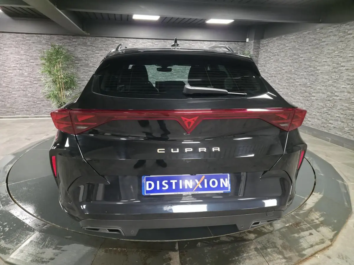 Vue arrière d'une CUPRA Formentor noire 2025 avec bandeau lumineux et double sortie d'échappement intégrée.