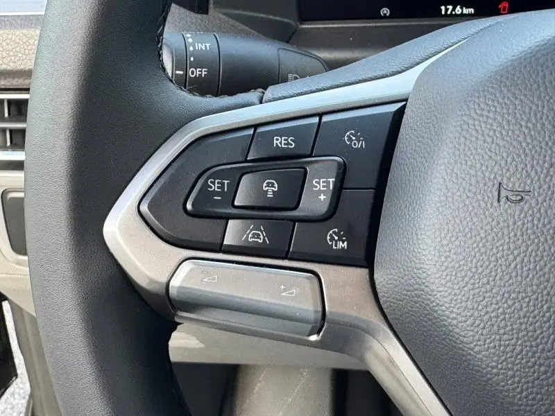 Gros plan sur les commandes multifonctions à gauche du volant cuir du Volkswagen Transporter FGN Midnight Black.