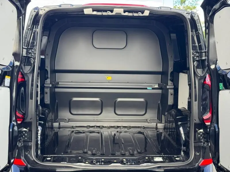 Vue arrière du Volkswagen Transporter Procab 2025 noir métallisé, montrant l'espace de chargement vide avec cloison en L.