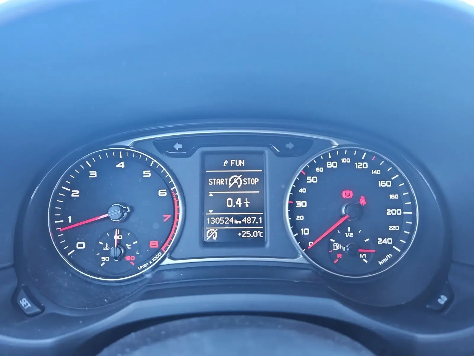 Vue rapprochée du tableau de bord de l'Audi A1 Sportback 2016, affichant compteurs et écran digital allumé.
