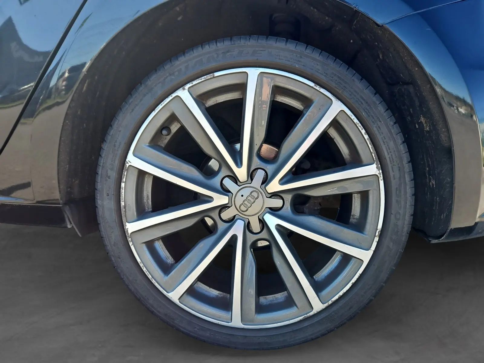 Gros plan sur la jante alliage 17 pouces de couleur argentée de l'Audi A1 Sportback noire, côté arrière droit.